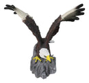 Majestic Soaring Bald Eagle Figurine with Outstretched Wings on Rocky Cliff