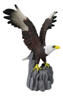 Majestic Soaring Bald Eagle Figurine with Outstretched Wings on Rocky Cliff