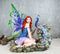 Large Fantasy Fairy With Blue Iridescent Train Wings Sitting By Peacock Statue