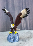 Majestic Soaring Bald Eagle Figurine with Outstretched Wings on Rocky Cliff