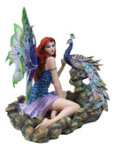 Large Fantasy Fairy With Blue Iridescent Train Wings Sitting By Peacock Statue