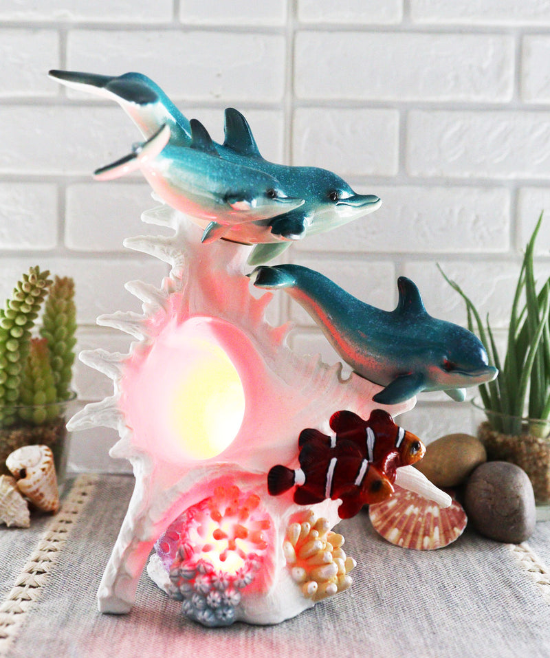 Ebros Nautical Ocean Family 3 Dolphins Swimming Over Giant Sea Conch Clownfishes and Anemones Statue with Colorful LED Light 9.5" Tall