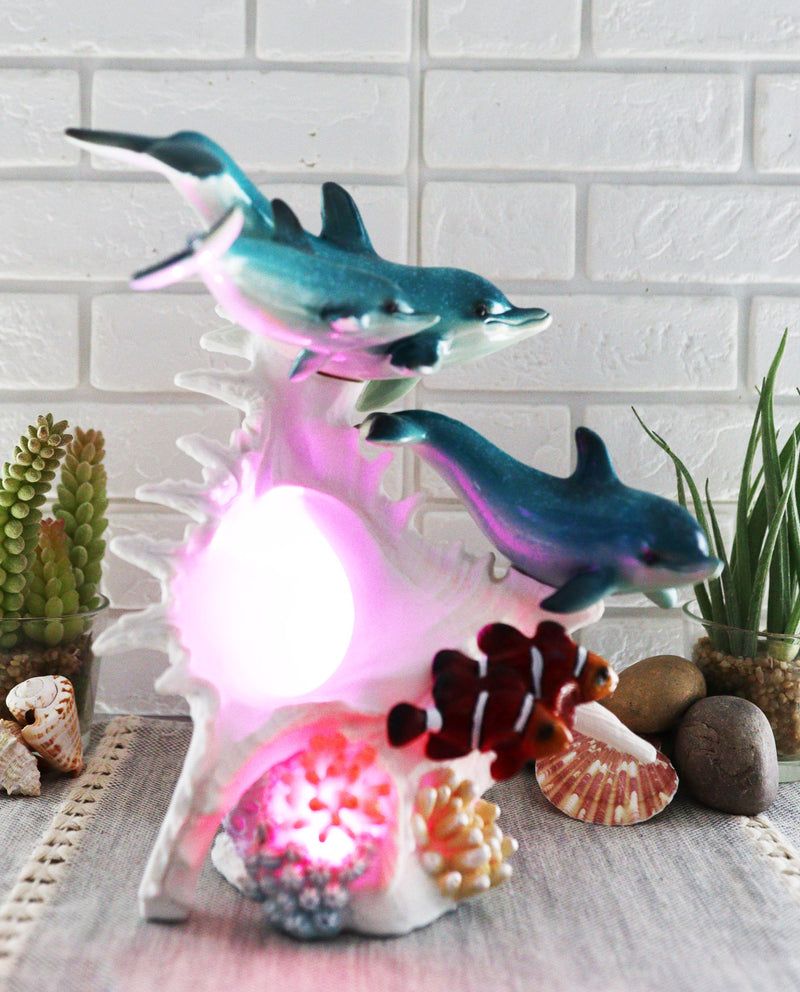 Ebros Nautical Ocean Family 3 Dolphins Swimming Over Giant Sea Conch Clownfishes and Anemones Statue with Colorful LED Light 9.5" Tall